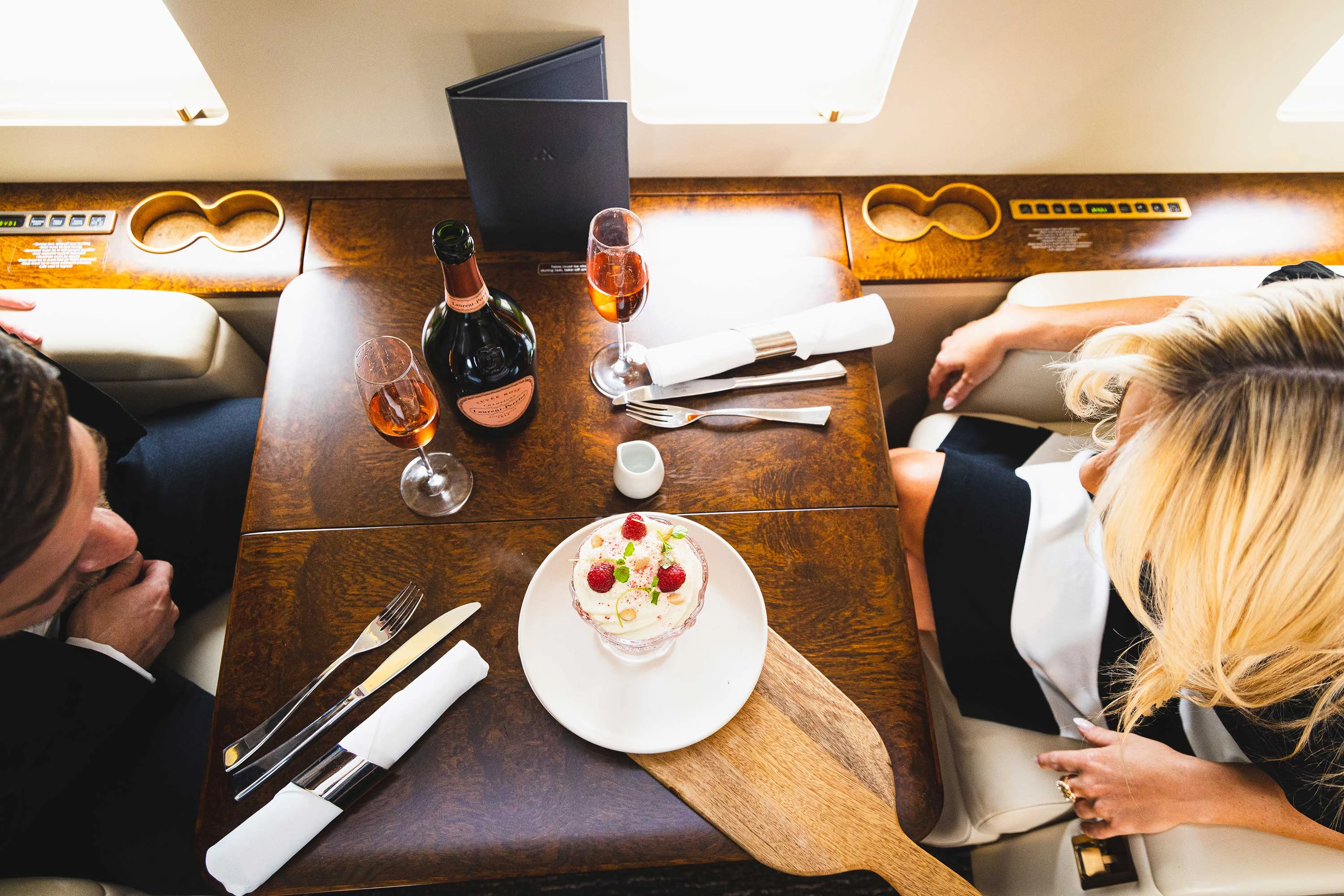 Plan view of a man and women having dessert on a flight.